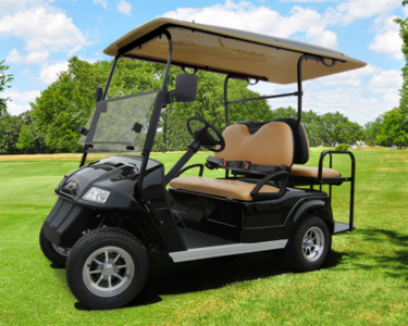 A black Star electric vehicle is parked on a green golf course track.