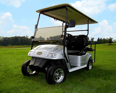 A silver Star electric vehicle that is parked on a piece of green golf pasture.