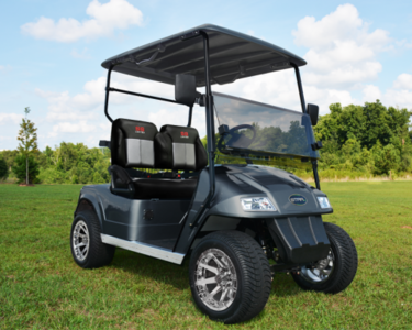 A black Star electric vehicle that is parked outside on the grass of a golf course.