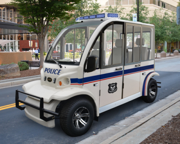 A Star electric vehicle that is designed to be a police vehicle sits outside parked on a road.