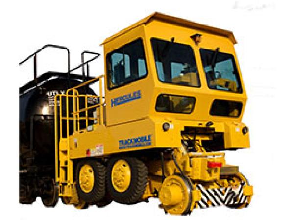 A large yellow Hercules railroad shunter is stationed in front of a white backdrop.